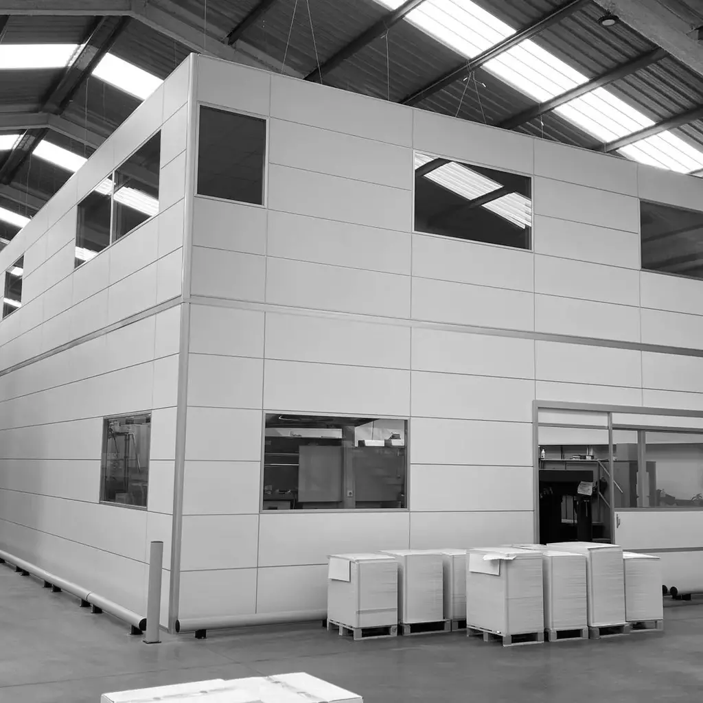 Nueva construcción de entrepiso dentro de un almacén, con paneles y escaleras metálicas para fácil acceso.