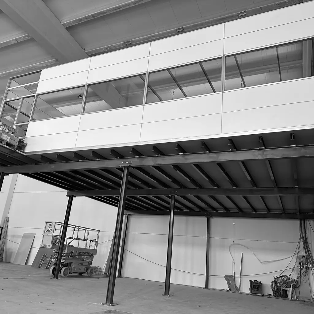 Estructura de entrepiso industrial robusta que se extiende sobre una zona de empaque y logística.
