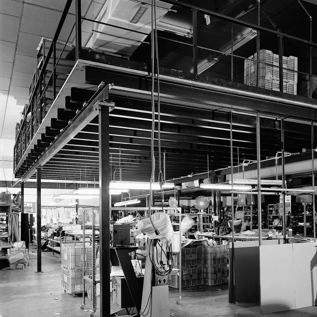 Zona de producción con altillo metálico, proporcionando espacio adicional sobre el suelo de la fábrica.